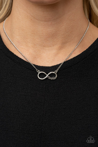 A bright silver infinity symbol features the word "Mother" in filigree script across the bottom. A row of sparkly dainty rhinestones travels across the curve creating a lovingly charming sentiment as it connects to a dainty silver chain below the collar. Features an adjustable clasp closure.